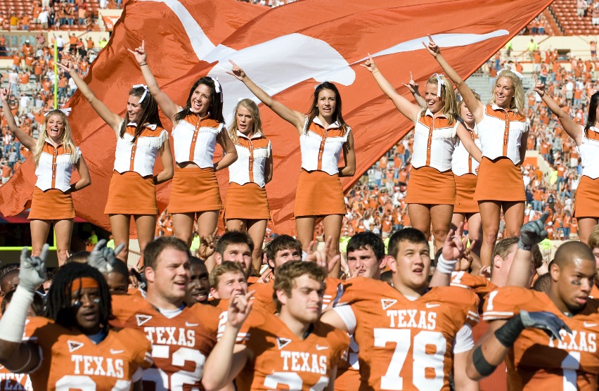 Longhorns football players and cheerleaders wearing the official colors of UT, burnt orange and white