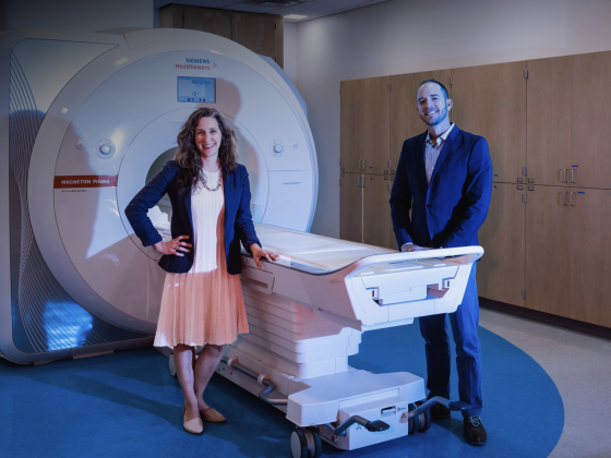 two faculty members posing in a portrait with an mri machine