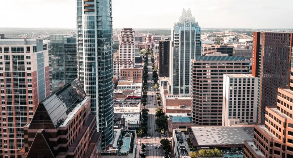 Austin city skyline. View of multiple skyscrapers during the day, including one large blue one with reflective glass.