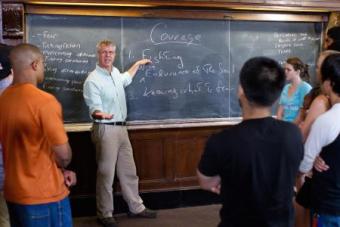 Teacher at chalk board teaching