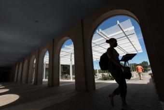 student walking in a portico at the UT Law School