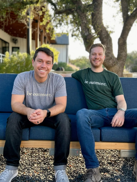 Two men sitting on a blue outdoor couch