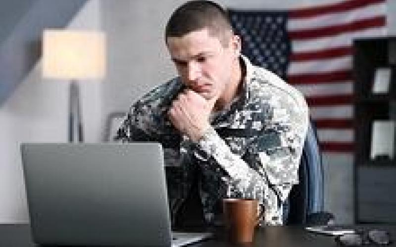 military stydent studying at laptop in camo